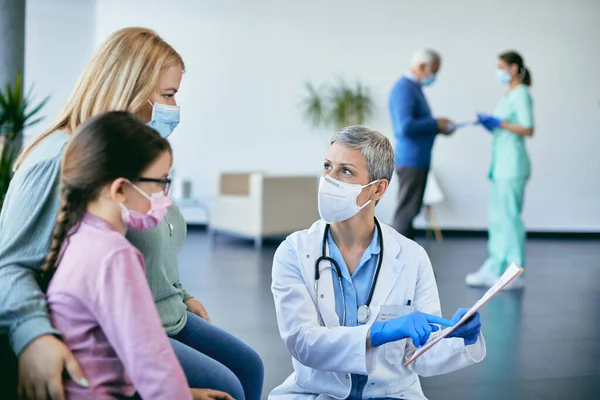 Female Doctor Explaining Data Medical Record Mother Daughter Waiting Room — 스톡 사진