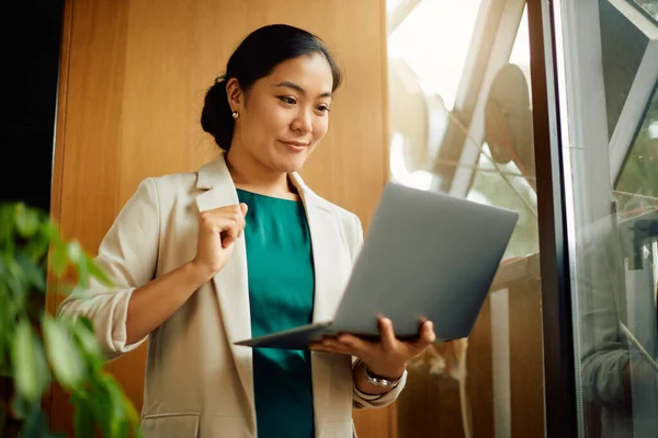 Smiling Asian Entrepreneur Working Laptop While Standing Window Her Office — Photo