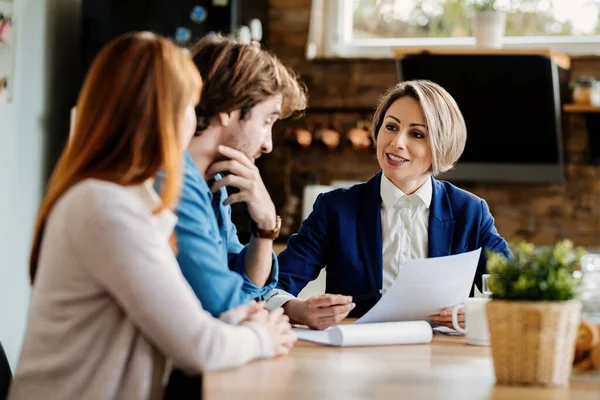 Happy Financial Advisor Young Couple Communicating While Going Paperwork Meeting — Fotografia de Stock