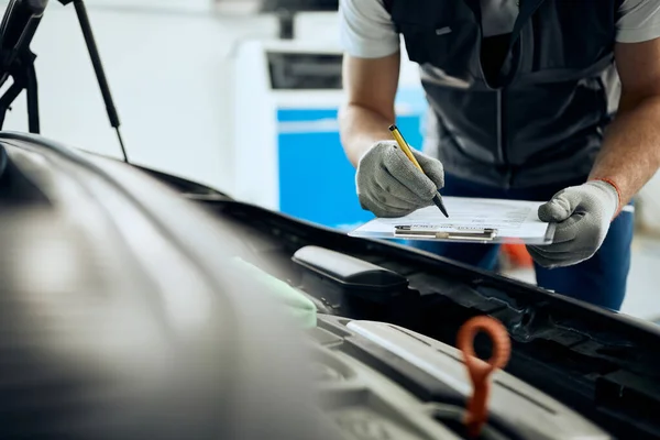 Close Car Mechanic Taking Notes While Analyzing Engine Auto Repair — Fotografia de Stock