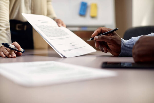 Close-up of black businessman signing an agreement in the office.