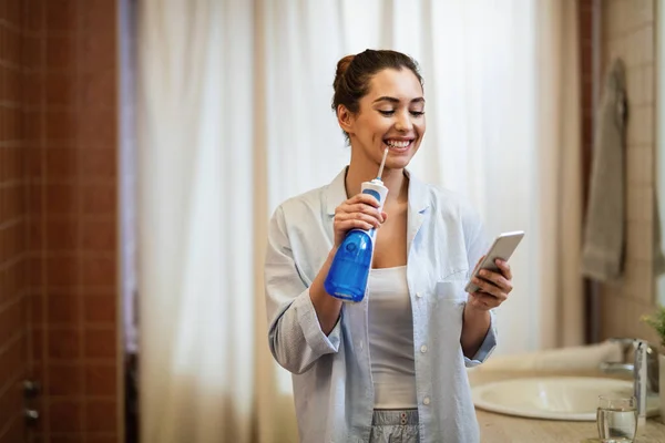Молода Щаслива Жінка Використовує Стоматологічну Водяну Мушку Чистить Зуби Під — стокове фото