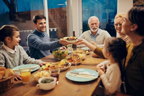 Happy Couple Passing Food While Having Family Lunch Dining Room — Foto Stock