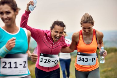 Cheerful runners having fun while participating in a race in nature. 