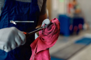 Close-up of auto repairman working in car workshop. 