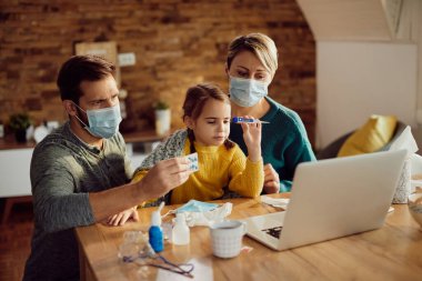 Worried parents and their ill daughter consulting a doctor via video call from home during coronavirus pandemic.