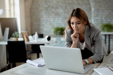Young businesswoman surfing the net on a computer while working in the office.