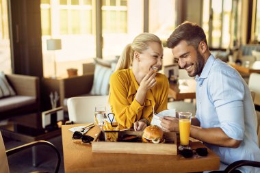 Happy couple talking and having fun while eating in a restaurant. 
