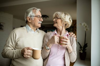Mutlu olgun çift evde kahve içerken iletişim kuruyor.. 