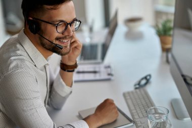 Young happy customer service representative working at call center. 