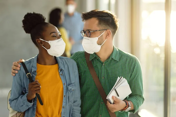 Happy University Couple Wearing Protective Face Masks While Walking Embraced — Foto Stock