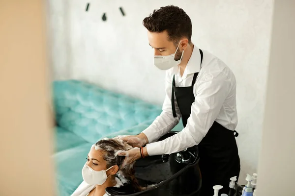Male Hairdresser Washing Woman Hair While Wearing Protective Face Masks — Zdjęcie stockowe