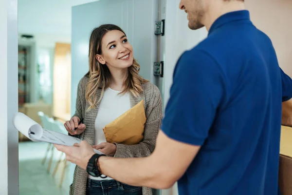 Happy Woman Standing Doorway Signing Package Delivery Courier — Stok Foto