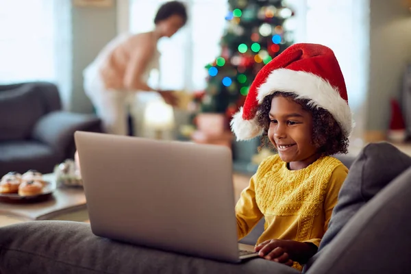Happy African American Girl Wearing Santa Hat Using Laptop While — ストック写真