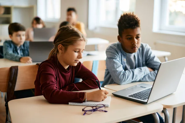 Schoolgirl Taking Notes While Learning Computer Her Classmate Elementary School — Stock Fotó