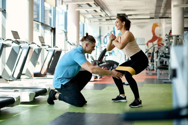 Personal Instructor Assisting Athletic Woman While She Practicing Squats Power — Stockfoto