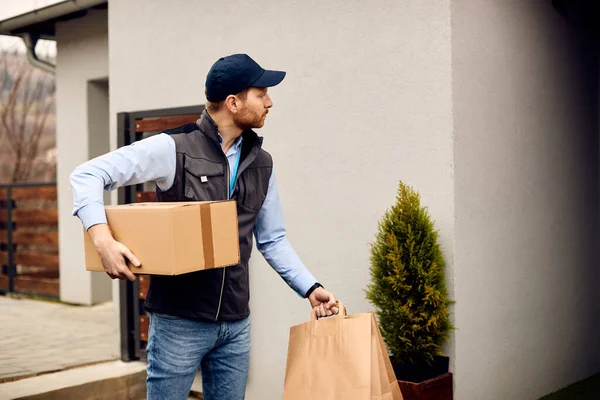 Delivery man delivering parcels to the place of residence of his customer.