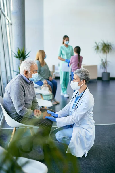Attentive Female Doctor Communicating Senior Man While Holding Hands His — Stockfoto