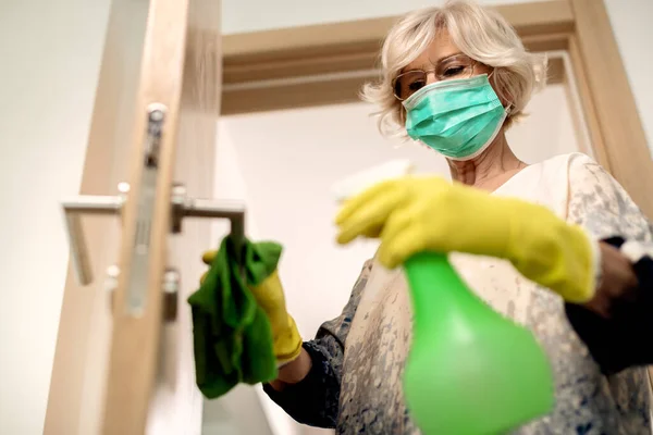 Low Angle View Senior Woman Disinfecting Door Handle Coronavirus Pandemic — Stock fotografie