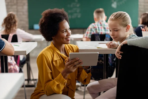 Happy African American Teacher Showing Something Touchpad Her Elementary Student — Stok Foto