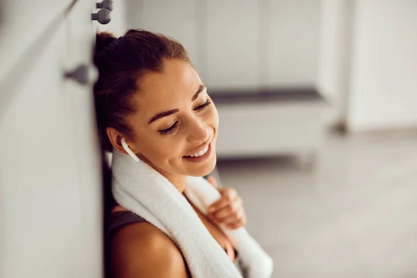 Smiling Sportswoman Feeling Fulfilled Sports Training Listening Music While Relaxing — Stockfoto