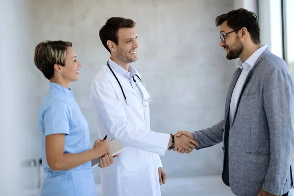 Happy Businessman Greeting Healthcare Workers Hallway Hospital Focus Doctor — Stockfoto