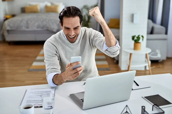 Happy Businessman Celebrating While Reading Good News Mobile Phone Home — Stockfoto