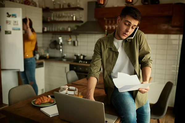 Male Entrepreneur Using Computer Going Paperwork While Communicating Cell Phone — Photo