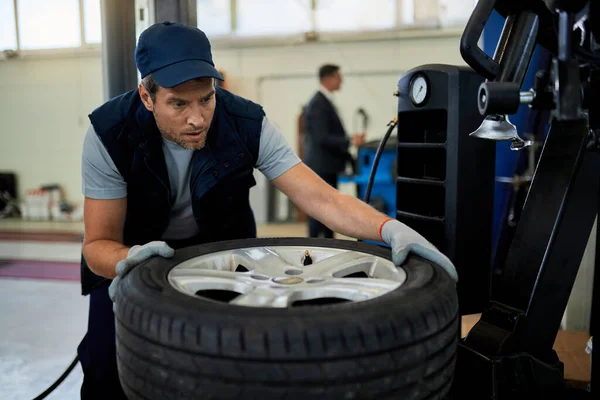 Auto Mechanic Examining Broken Car Tire While Working Workshop — Fotografia de Stock
