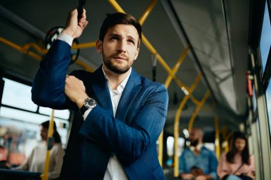 Low angle view of businessman commuting to work by public transport.