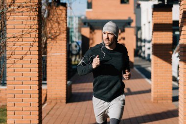 Young male runner jogging on the street. 