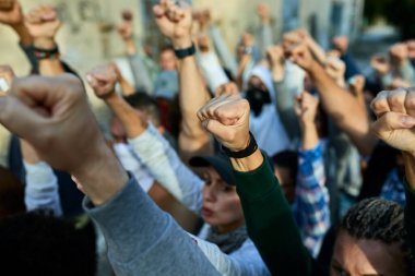 Close-up of large group of people with raised fists on public demonstrations. 