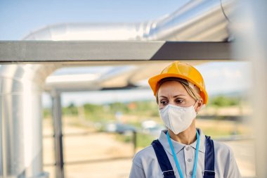 Female construction engineer with protective face mask in inspec