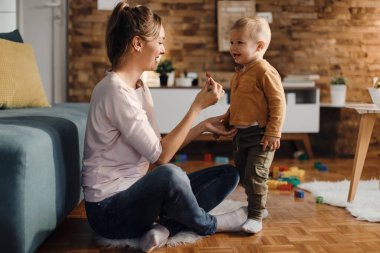 Happy mother and her cute son enjoying at home together. 