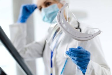 Coronavirus salgını sırasında hastanede çalışırken vizör kullanan kadın doktorların yakın çekimleri..