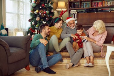 Joyful multi-generation family enjoying in Christmas and having fun together at home.