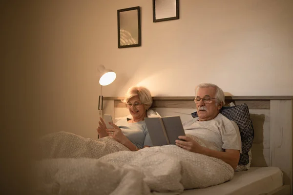 Mature Couple Pajamas Relaxing Bed Night Woman Using Mobile Phone — ストック写真