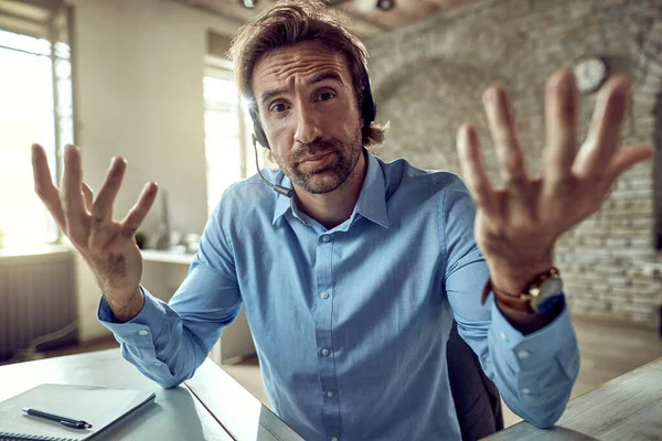 Young Displeased Businessman Wearing Headset Gesturing While Looking Camera Office — Photo