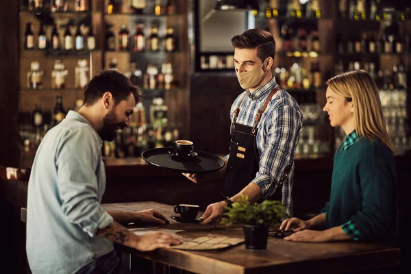 Happy Waiter Serving Coffee Customers Wearing Protective Face Mask Due — 스톡 사진