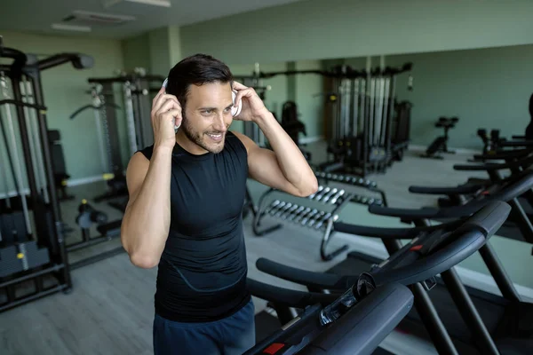 Happy Athlete Adjusting His Headphones While Preparing Running Treadmill Gym — ストック写真