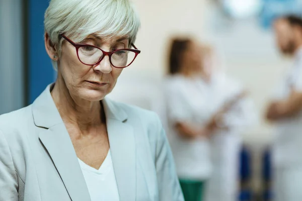 Worried Senior Woman Thinking Something While Standing Lobby Clinic — Foto de Stock