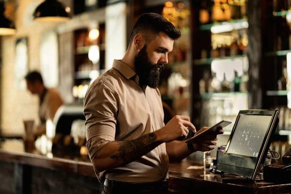 Young Bartender Using Digital Tablet While Working Pub — ストック写真