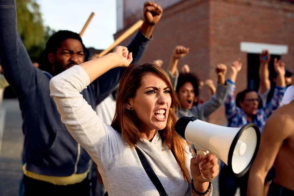 Young Displeased Woman Using Megaphone Shouting While Protesting Group People —  Fotos de Stock