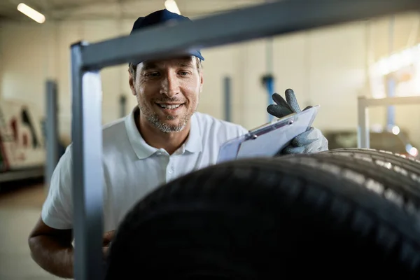 Happy Auto Repairman Checking Stack Car Tires While Working Workshop — Fotografia de Stock