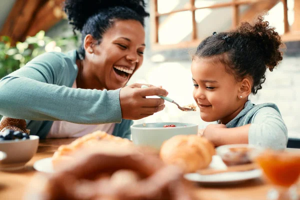 Happy Black Mother Having Fun Feeding Her Daughter While Having — Foto de Stock