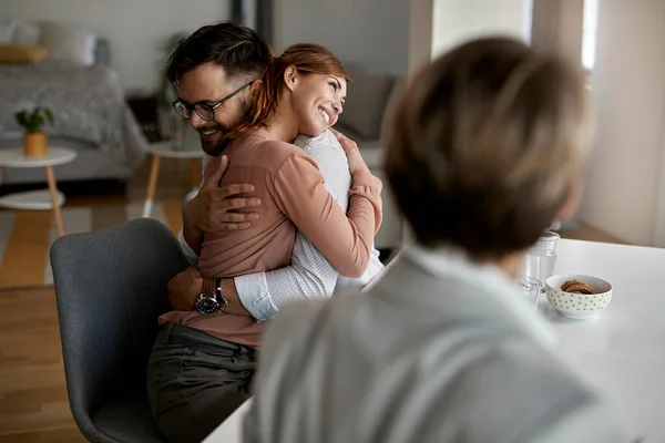 Young Happy Couple Embracing Meeting Real Estate Agent — Stockfoto