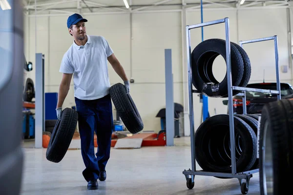 Mid Adult Car Mechanic Carrying Tires While Working Auto Repair — Fotografia de Stock