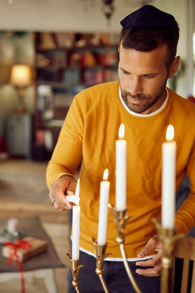 Mid Adult Man Lightning Menorah While Celebrating Hanukkah Home — Stockfoto