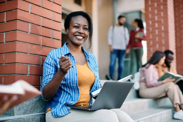 Χαρούμενος Αφροαμερικανός Φοιτητής Που Χρησιμοποιεί Φορητό Υπολογιστή Στην Πανεπιστημιούπολη Και — Φωτογραφία Αρχείου