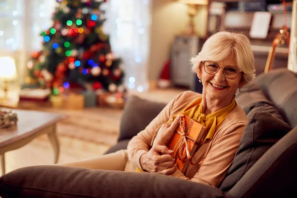 Happy Mature Woman Holding Books While Relaxing Home Christmas Looking — Photo